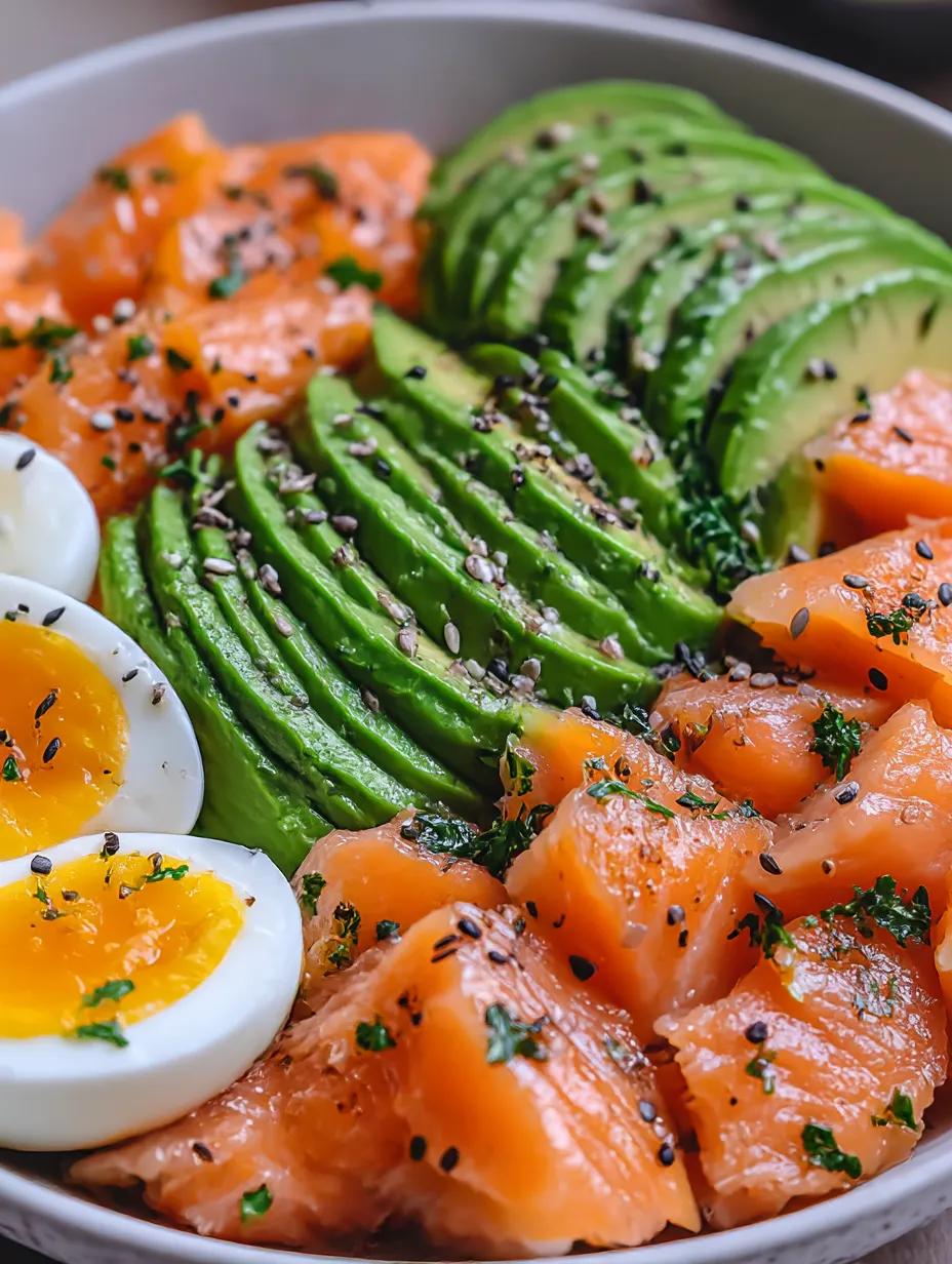 A bowl of food with eggs, avocado, and salmon.