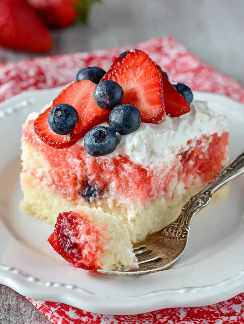 A slice of cake with strawberries and blueberries on top.