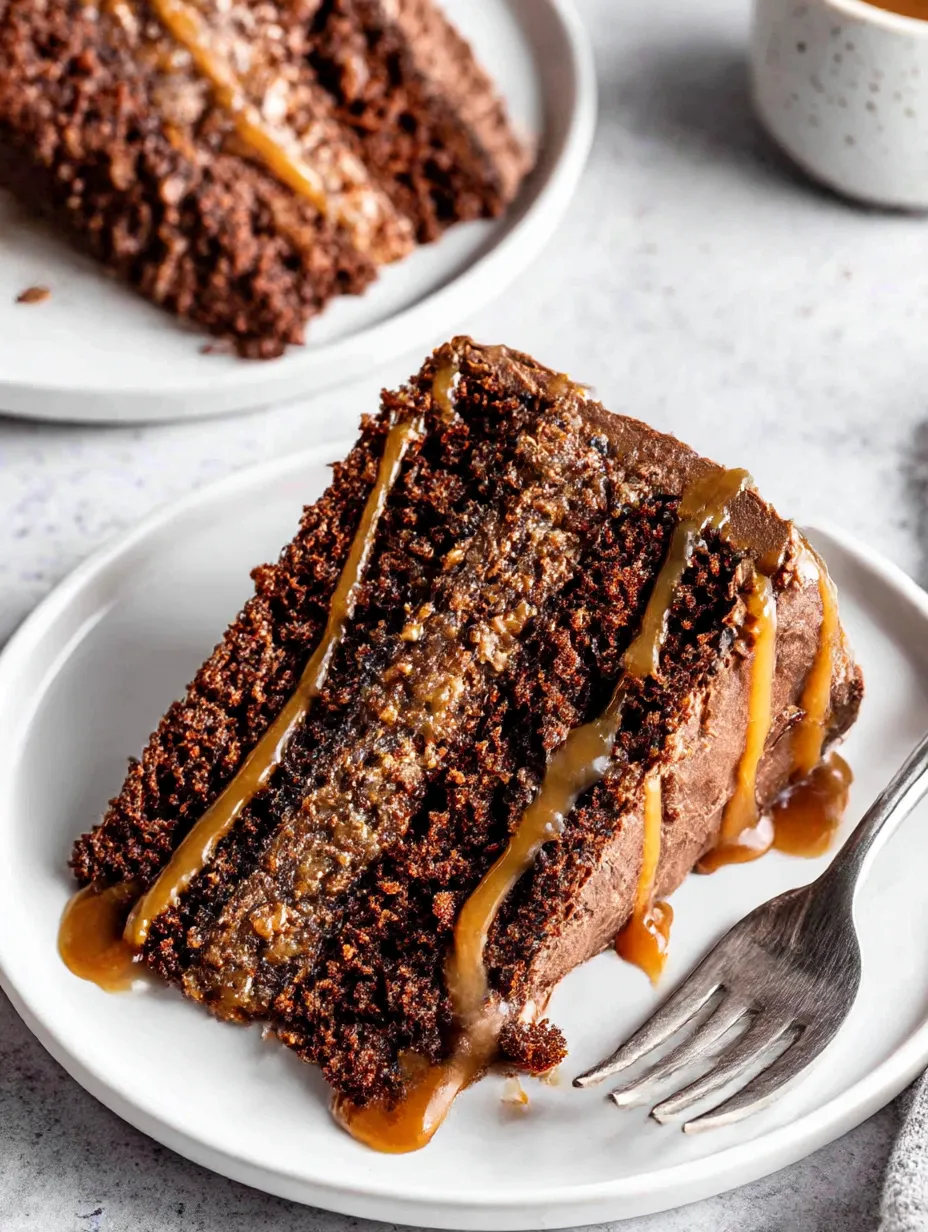 A slice of moist chocolate caramel cake on a white plate.