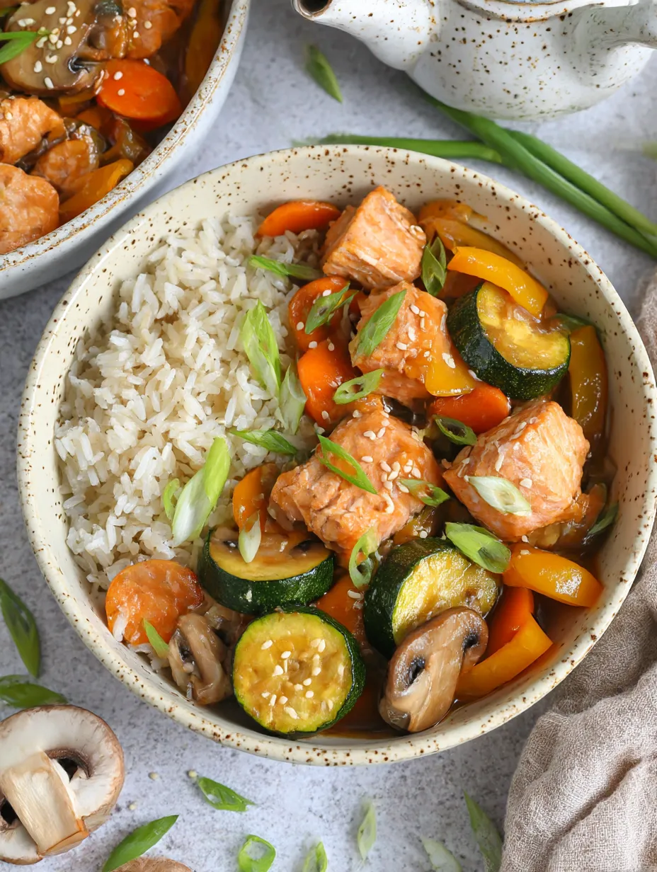 A bowl of rice and vegetables with a salmon stir fry.